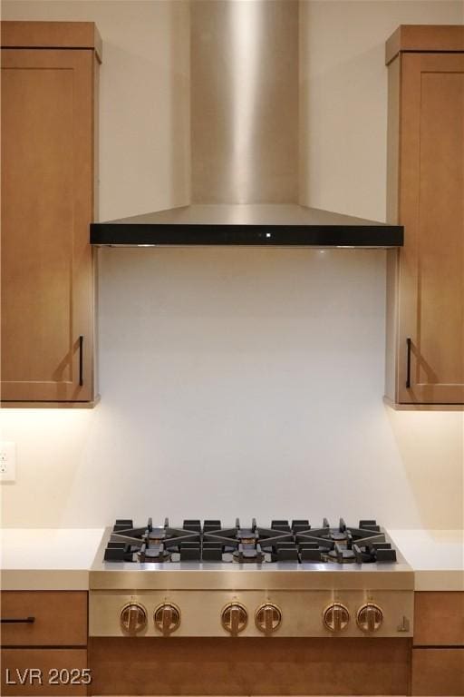 182 Robledo St, Las Vegas, NV 89138 - kitchen view of wall chimney exhaust hood, stainless steel gas cooktop, light countertops, and brown cabinets