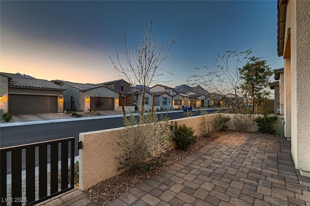 182 Robledo St, Las Vegas, NV 89138 - patio terrace at dusk with a residential view and a garage
