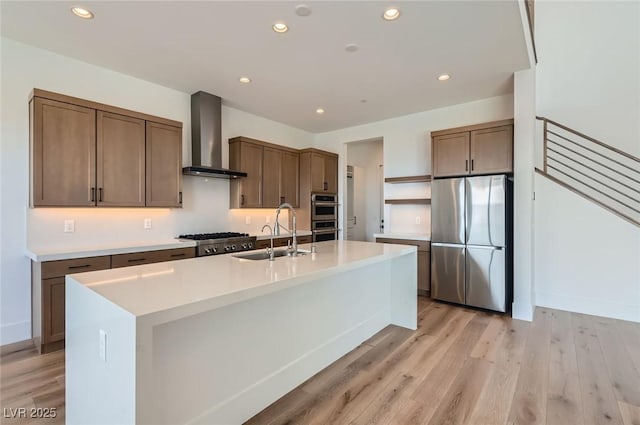 182 Robledo St, Las Vegas, NV 89138 - kitchen featuring appliances with stainless steel finishes, wall chimney range hood, a sink, recessed lighting, and light wood finished floors