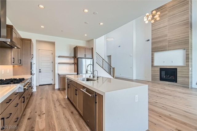182 Robledo St, Las Vegas, NV 89138 - kitchen featuring open shelves, a sink, stainless steel appliances, wall chimney exhaust hood, and light wood-style floors