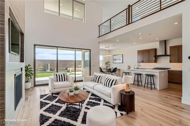 182 Robledo St, Las Vegas, NV 89138 - living room with light wood-type flooring, a large fireplace, and a high ceiling