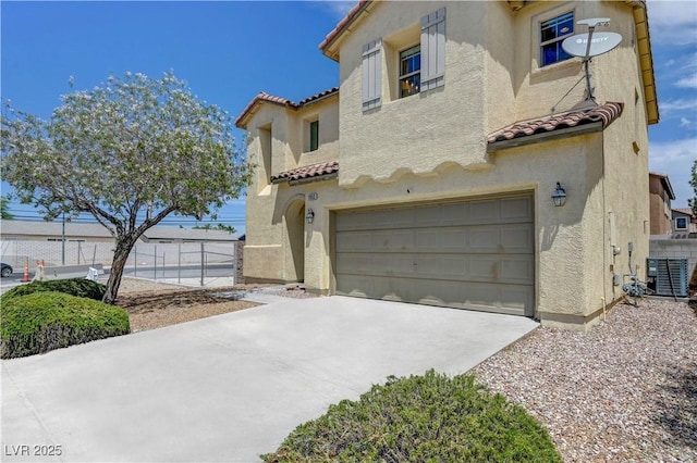 1952 W Hammer Ln, North Las Vegas, NV 89031 - mediterranean / spanish-style home featuring a tile roof, stucco siding, central AC unit, an attached garage, and concrete driveway