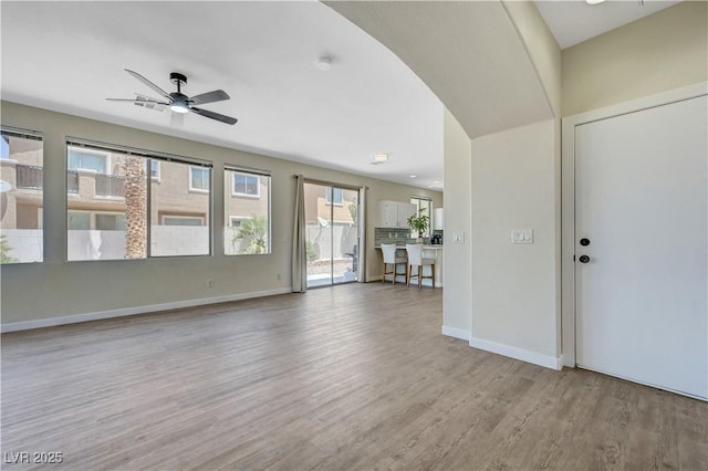 1952 W Hammer Ln, North Las Vegas, NV 89031 - unfurnished living room featuring a ceiling fan, wood finished floors, and baseboards