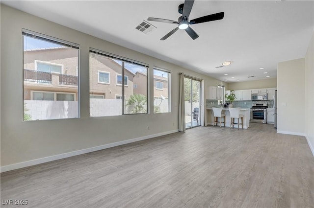 1952 W Hammer Ln, North Las Vegas, NV 89031 - unfurnished living room with light wood-type flooring, baseboards, and ceiling fan