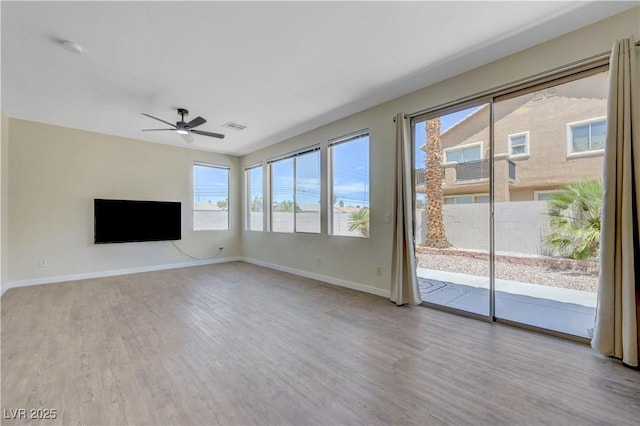 1952 W Hammer Ln, North Las Vegas, NV 89031 - unfurnished living room featuring wood finished floors, a ceiling fan, and baseboards