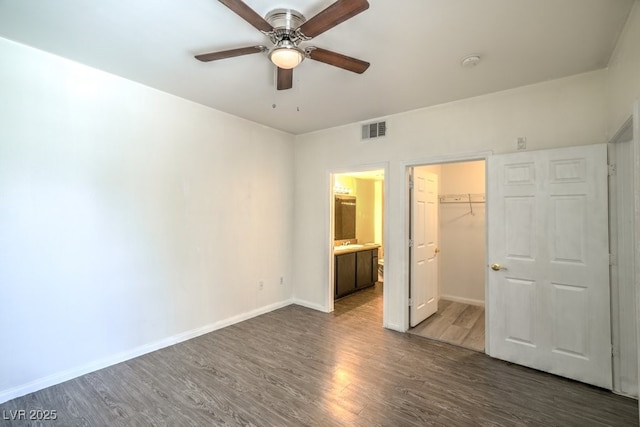 8000 Badura Ave Unit 1168, Las Vegas, NV 89113 - unfurnished bedroom with wood finished floors, baseboards, a walk in closet, a closet, and connected bathroom