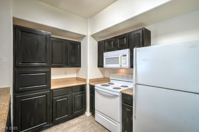 8000 Badura Ave Unit 1168, Las Vegas, NV 89113 - kitchen with white appliances, dark cabinetry, light countertops, and light wood finished floors