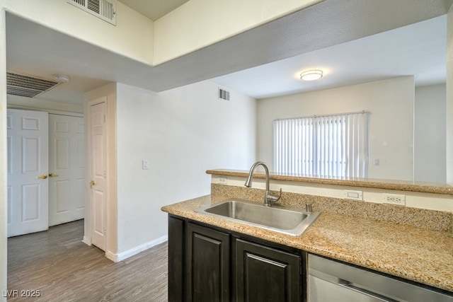 8000 Badura Ave Unit 1168, Las Vegas, NV 89113 - kitchen featuring a sink, stainless steel dishwasher, light wood finished floors, baseboards, and light stone countertops