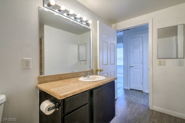 8000 Badura Ave Unit 1168, Las Vegas, NV 89113 - bathroom with wood finished floors, toilet, vanity, and baseboards