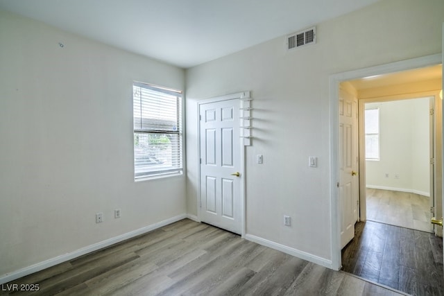 8000 Badura Ave Unit 1168, Las Vegas, NV 89113 - unfurnished bedroom featuring wood finished floors, multiple windows, and baseboards