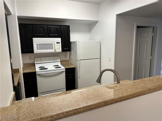 8000 Badura Ave Unit 1168, Las Vegas, NV 89113 - kitchen featuring white appliances, dark cabinets, and light stone counters