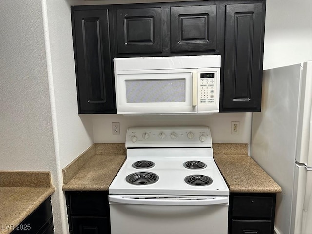 8000 Badura Ave Unit 1168, Las Vegas, NV 89113 - kitchen with white appliances, dark cabinets, and light countertops