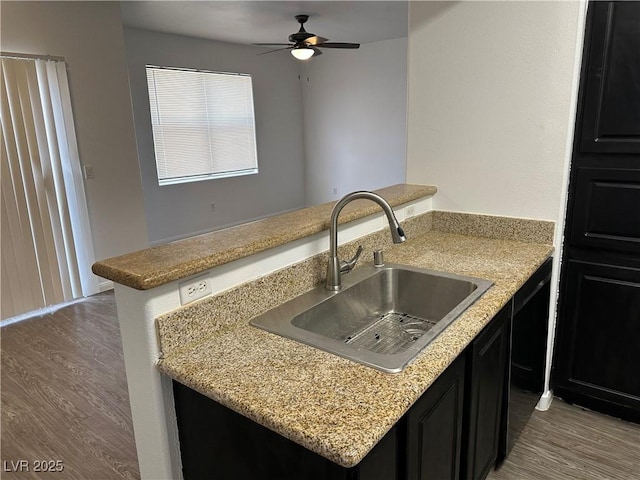 8000 Badura Ave Unit 1168, Las Vegas, NV 89113 - kitchen featuring wood finished floors, dark cabinets, ceiling fan, and a peninsula