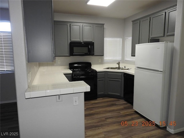 75 N Valle Verde Dr Unit 411, Henderson, NV 89074 - kitchen featuring black appliances, gray cabinetry, a sink, dark wood-type flooring, and tile counters