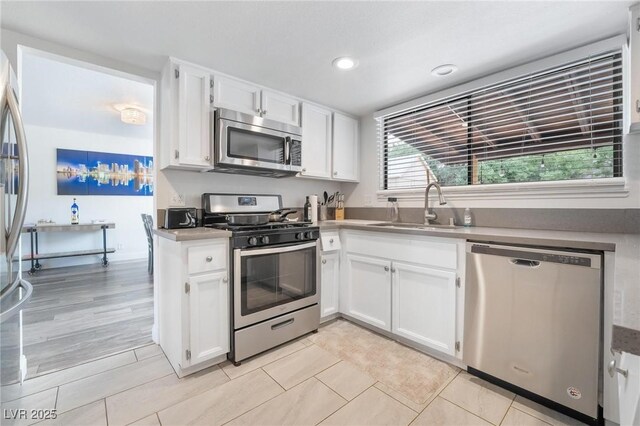 7009 Rawlins Ct, Las Vegas, NV 89128 - kitchen with appliances with stainless steel finishes, a sink, white cabinets, recessed lighting, and light tile patterned flooring