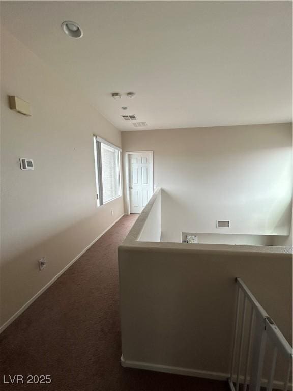 6812 Dipper Ave, North Las Vegas, NV 89084 - hall featuring an upstairs landing, dark colored carpet, and baseboards