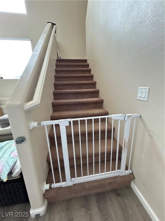 6812 Dipper Ave, North Las Vegas, NV 89084 - stairway with wood finished floors and baseboards