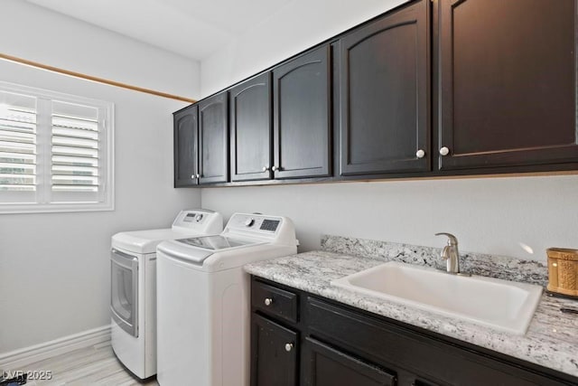 8121 Eagle Clan Ct, Las Vegas, NV 89131 - laundry room with cabinet space, washer and dryer, light wood-style flooring, and baseboards