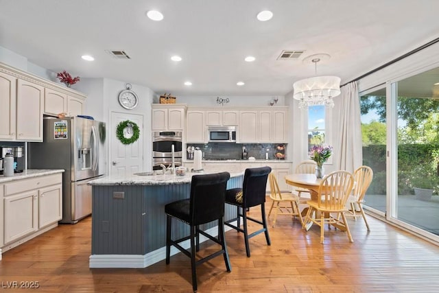 8121 Eagle Clan Ct, Las Vegas, NV 89131 - kitchen with stainless steel appliances, backsplash, a chandelier, light wood-style flooring, and recessed lighting