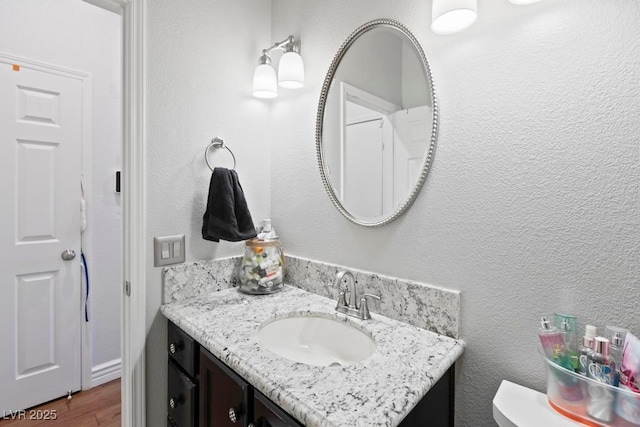 8121 Eagle Clan Ct, Las Vegas, NV 89131 - half bath with vanity, toilet, wood finished floors, and a textured wall