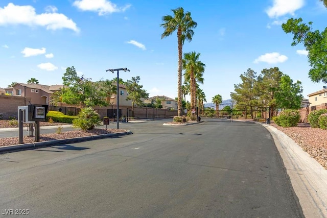 8121 Eagle Clan Ct, Las Vegas, NV 89131 - view of asphalt street featuring a residential view, a gate, a gated entry, and curbs