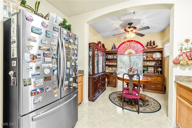 7724 Somerhill Point Way, Las Vegas, NV 89139 - kitchen with freestanding refrigerator, a ceiling fan, light stone counters, and light tile patterned floors