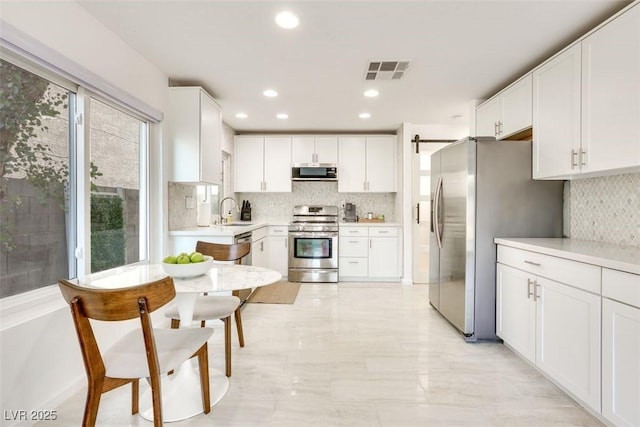 2429 Worchester Rd, Henderson, NV 89074 - kitchen with appliances with stainless steel finishes, backsplash, white cabinetry, light countertops, and a sink