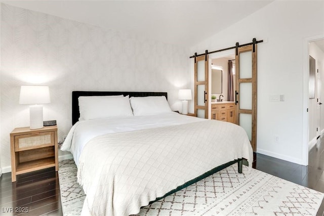 2429 Worchester Rd, Henderson, NV 89074 - bedroom featuring a barn door, wood finished floors, and baseboards