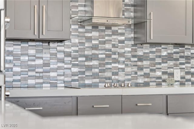 3111 Bel Air Dr Unit 22B, Las Vegas, NV 89109 - detailed view of gray cabinets, wall chimney range hood, backsplash, and light countertops