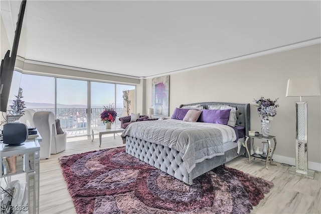 3111 Bel Air Dr Unit 22B, Las Vegas, NV 89109 - bedroom with access to exterior, crown molding, and light wood-style flooring