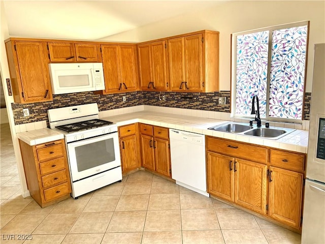 3665 Lucky Horseshoe Ct, Las Vegas, NV 89129 - kitchen featuring white appliances, a sink, tile countertops, tasteful backsplash, and brown cabinetry