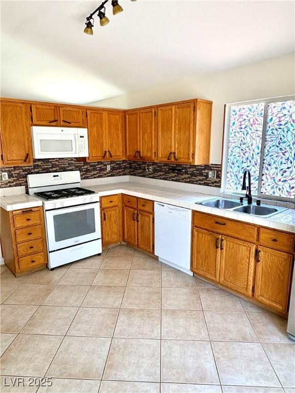 3665 Lucky Horseshoe Ct, Las Vegas, NV 89129 - kitchen with white appliances, a sink, backsplash, brown cabinets, and lofted ceiling