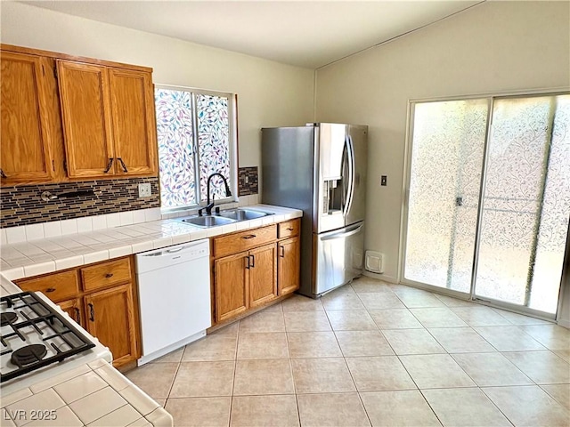 3665 Lucky Horseshoe Ct, Las Vegas, NV 89129 - kitchen featuring white dishwasher, a sink, stainless steel fridge with ice dispenser, backsplash, and brown cabinetry