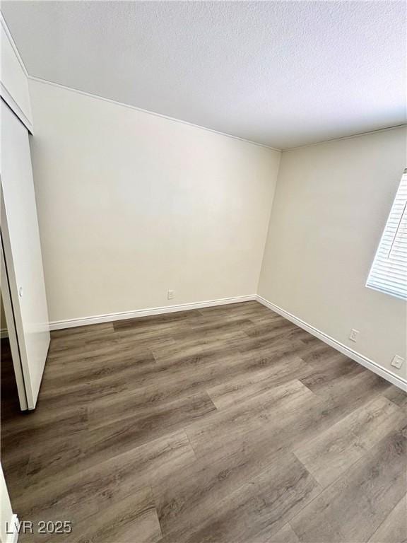 3665 Lucky Horseshoe Ct, Las Vegas, NV 89129 - unfurnished bedroom with wood finished floors, baseboards, a closet, and a textured ceiling