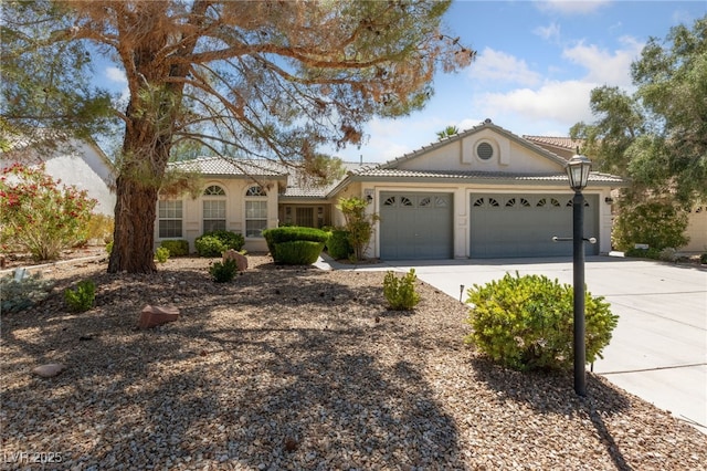 5232 Saranac Rd, Las Vegas, NV 89130 - view of front of house with a garage, concrete driveway, stucco siding, and a tiled roof