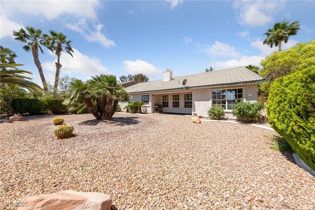 5232 Saranac Rd, Las Vegas, NV 89130 - back of house featuring a tiled roof, stucco siding, and a chimney