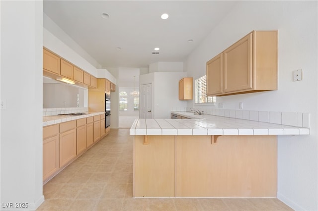 5232 Saranac Rd, Las Vegas, NV 89130 - kitchen featuring a peninsula, light brown cabinetry, tile countertops, white gas stovetop, and recessed lighting