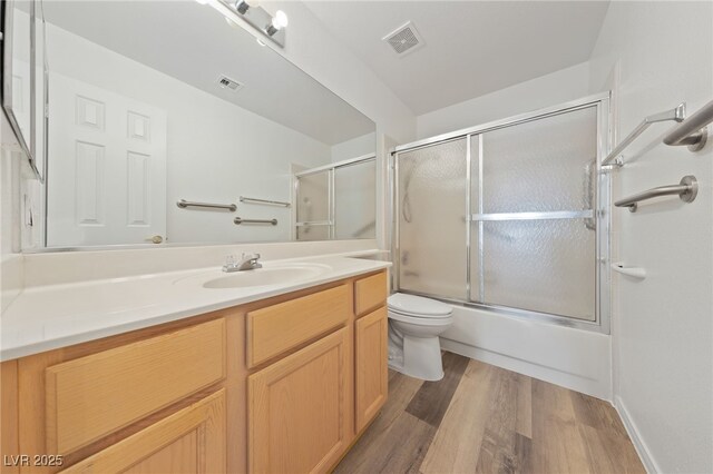 5232 Saranac Rd, Las Vegas, NV 89130 - full bath featuring toilet, vanity, wood finished floors, and shower / bath combination with glass door