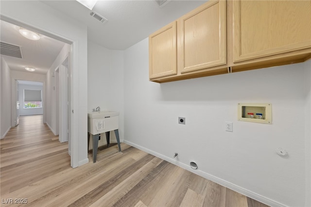 5232 Saranac Rd, Las Vegas, NV 89130 - washroom featuring cabinet space, hookup for a gas dryer, hookup for a washing machine, light wood-style flooring, and electric dryer hookup
