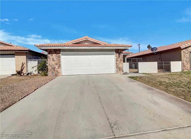 1832 Yellow Rose St, Las Vegas, NV 89108 - ranch-style house with stone siding, a gate, a garage, a tiled roof, and concrete driveway