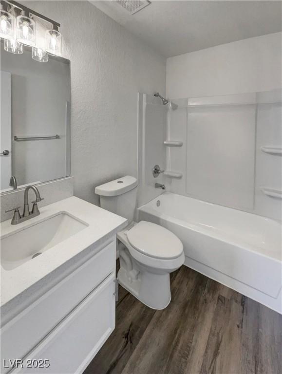 1832 Yellow Rose St, Las Vegas, NV 89108 - bathroom featuring wood finished floors, toilet, shower / bath combination, vanity, and a textured wall