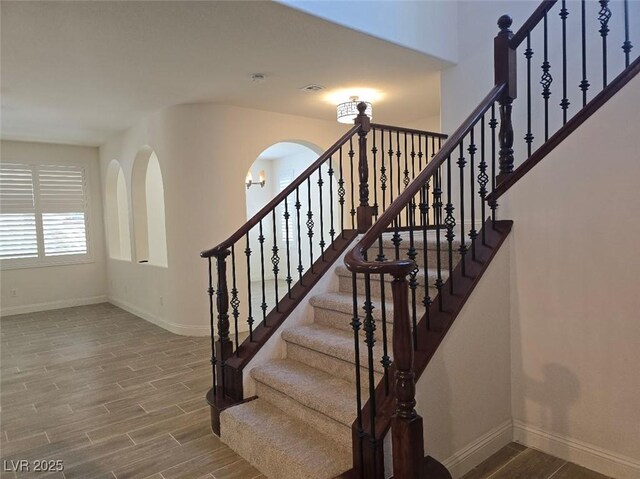 11298 Corsica Mist Ave, Las Vegas, NV 89135 - staircase with wood finished floors and arched walkways