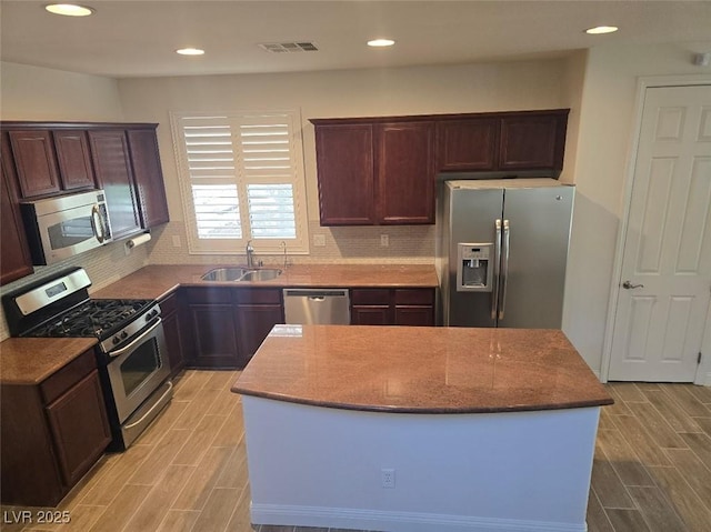 11298 Corsica Mist Ave, Las Vegas, NV 89135 - kitchen with appliances with stainless steel finishes, wood finish floors, a kitchen island, decorative backsplash, and recessed lighting