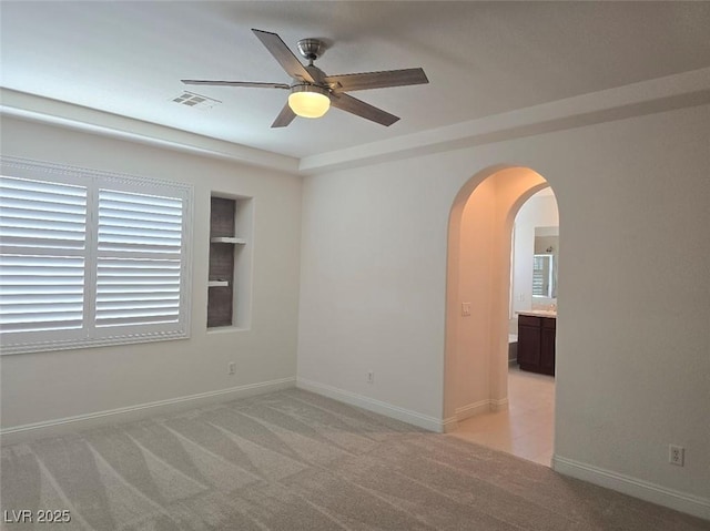 11298 Corsica Mist Ave, Las Vegas, NV 89135 - empty room featuring ceiling fan, arched walkways, light carpet, and built in shelves