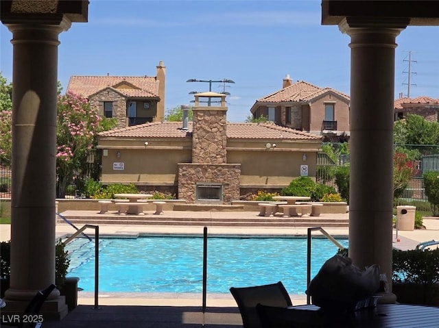 11298 Corsica Mist Ave, Las Vegas, NV 89135 - community pool featuring an outdoor stone fireplace and a patio area