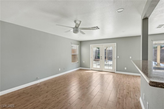 4552 Aviation St, Las Vegas, NV 89115 - unfurnished room featuring french doors, healthy amount of natural light, wood finished floors, baseboards, and a textured ceiling