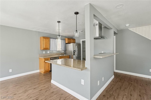4552 Aviation St, Las Vegas, NV 89115 - kitchen with stainless steel refrigerator with ice dispenser, wall chimney range hood, a sink, light wood-style floors, and dishwasher