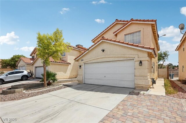 4552 Aviation St, Las Vegas, NV 89115 - view of front of home with driveway, a tiled roof, and stucco siding