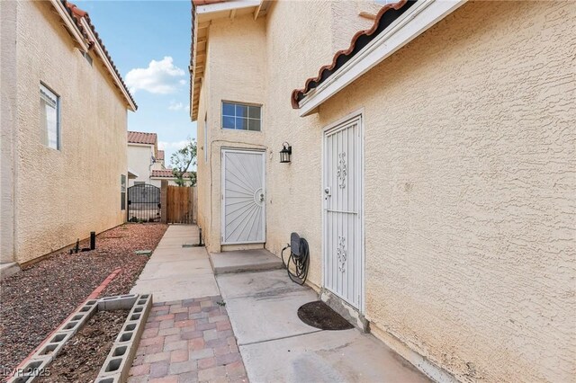 4552 Aviation St, Las Vegas, NV 89115 - doorway to property featuring stucco siding, a gate, and a tiled roof