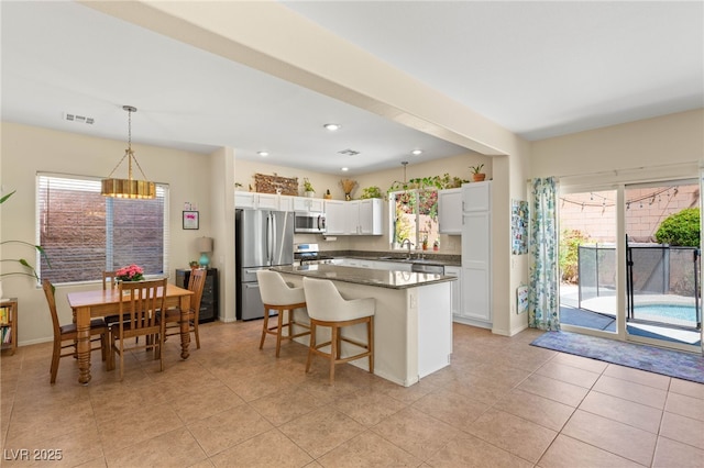 11226 Kenyan Sunshine Ct, Las Vegas, NV 89138 - kitchen featuring appliances with stainless steel finishes, a sink, a kitchen island, white cabinets, and hanging light fixtures